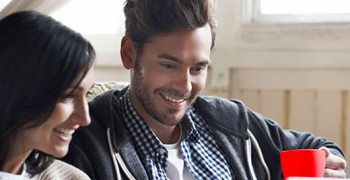 couple sur un canapé devant un ordinateur